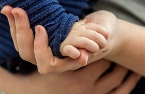 toddler hand held by adult