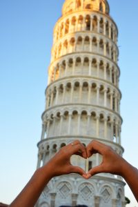 Tower of Pisa with hand in front in shape of a heart