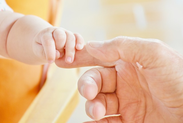 BABY AND PARENT HOLDING HANDS
