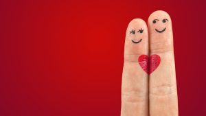 2 FINGERS WITH HEARTS PAINTED ON THEM